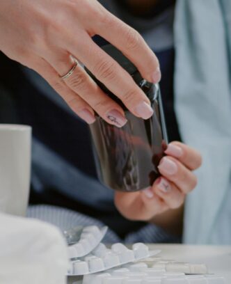 close-up-woman-reading-labels-tablets-jars-with-pills-capsules-table-with-medicaments-tissues-thermometer-sick-person-looking-treatment-cure-virus-symptoms_482257-29021