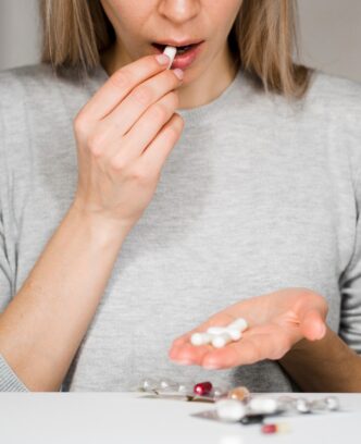 close-up-woman-taking-pill_23-2148504592